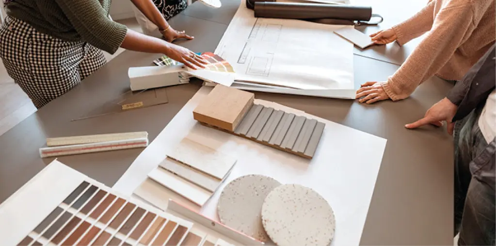 Beratungssituation am Tisch mit Farb- und Materialmustern, Holzproben und Planungsunterlagen für Raumgestaltung und Innenarchitektur, moderne Wohnberatung und Einrichtungskonzept.
